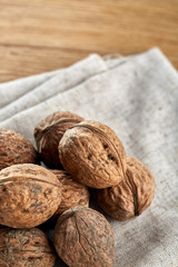A stack of walnuts piled together and on rustic wooden background, shallow depth of field, selective focus