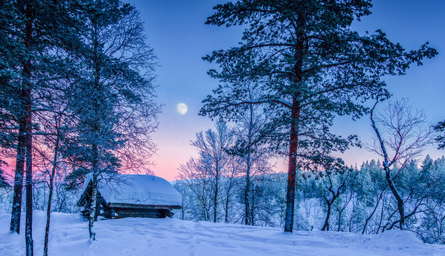 Winter wonderland in Scandinavia with moon at sunset