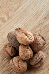 A stack of walnuts piled together and on rustic wooden background, shallow depth of field, selective focus