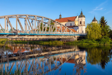 Fototapeta na wymiar View at bridge over the Narew river and baroque Church in Tykocin town, Podlasie, Poland