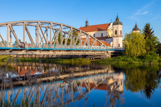 View at bridge over the Narew river and baroque Church in Tykocin town, Podlasie, Poland