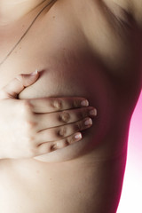 Woman with hands on breasts on a pink background / Outubro Rosa