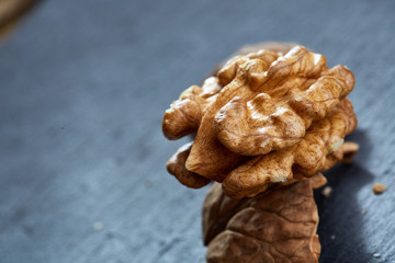 Top view close-up shot of cracked walnuts on dark background, shallow depth of field, macro