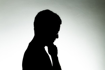 Man in backlight with glasses on a white background
