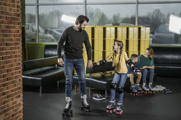 father and daughter going on roller rink to skate in skate park