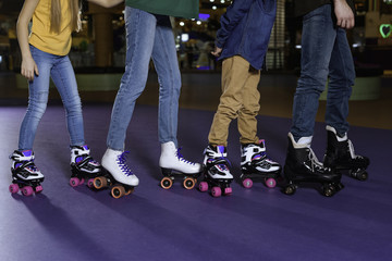 partial view of parents and kids skating on roller rink together