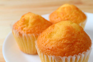 Close-up of Delectable Madeleine Cupcakes Served on White Plate, Selective Focus and Blurred Background 