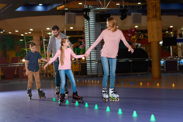 family spending time together on roller rink with cones