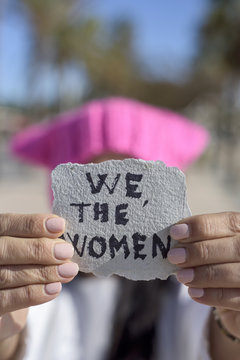 woman with a pink hat and the text we the women