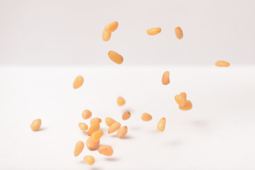 Useful pine nuts fall down on a white background