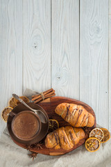 morning breakfast, composition of coffee and croissants on a wooden background