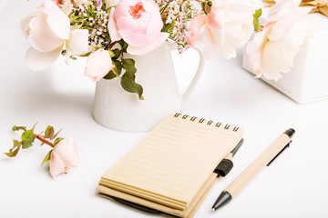Holiday card, beautiful fresh pink English rose, gift, notebook , pen, pencil on white background. Birthday, Mother's, Women's, Wedding Day concept.
