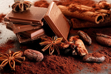 Broken dark chocolate, cocoa powder and coffee beans on a wooden table