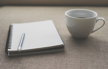 Coffee in white cup with Journal book and pencil