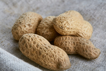 Heap of peanuts on light tablecloth, close-up, shallow depth of field, selective focus, macro