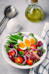 nicoise salad with tuna, anchovies, eggs, green beans, olives, tomatoes, red onions and salad leaves