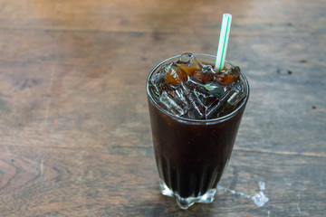 Thailand ice coffee in glass on wooden table.