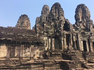Fototapeta premium Angkor Wat in Siem Reap, Cambodia. Stone faces carved in the ancient ruins of Bayon Khmer Temple
