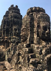 Angkor Wat in Siem Reap, Cambodia. Stone faces carved in the ancient ruins of Bayon Khmer Temple