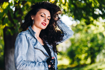 Portrait of a beautiful smiling woman with a a nice long curve hairstyle in nature / outdoors. Look into the distance.