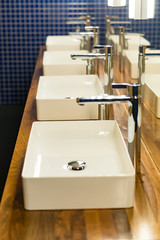 Row of wash sinks in public bathroom, closeup
