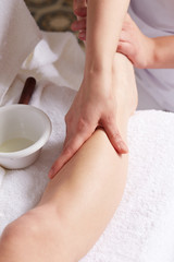 Fototapeta na wymiar Female Enjoying Relaxing legs Massage In Cosmetology Spa Center