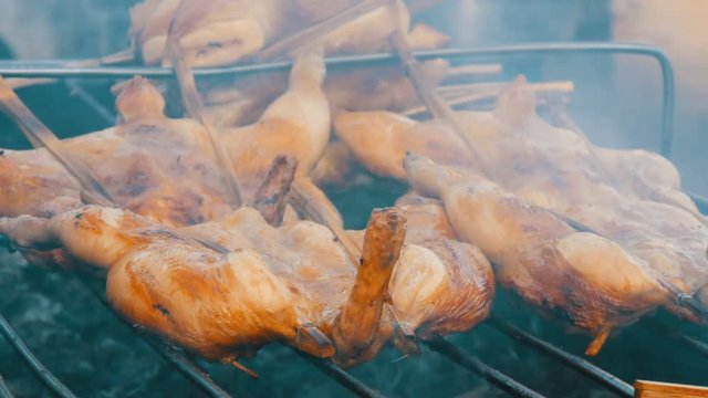 Whole chicken carcass grill strung on wooden stick grilling on the grill. Street Food Thailand