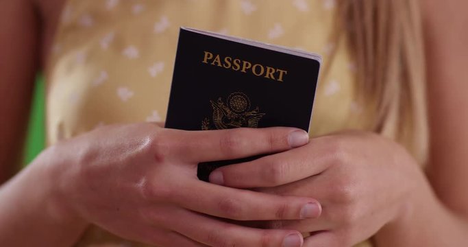 Close up of woman holding passport in her hands ready for international travel. Caucasian millennial tourist in her 20s with paper identification documents. 4k on green for keying or compositing