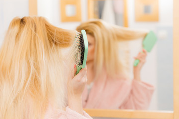 Fototapeta premium Woman wearing dressing gown brushing her hair