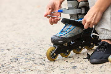 Woman putting on roller skates outdoor.