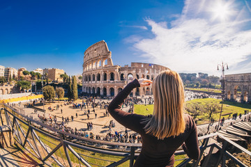 Woman tourist enjoying the view of the Roman Colosseum in Rome, Italy
