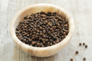 Whole Black Pepper in a marble bowl ,still life  selective focus