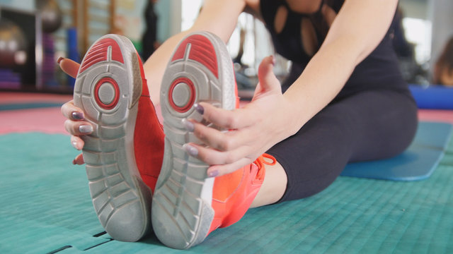 Straching in the gym - young woman exercising healthy lifestyle in fitness studio