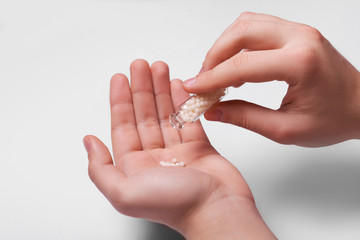 Man's hands pouring a dose of homeopathic pills on white background