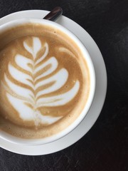 Cup of coffe with cream art on black background 