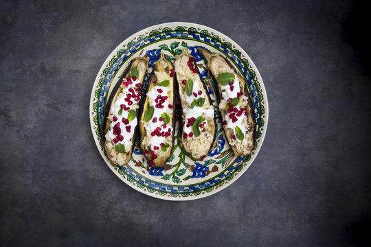 Aubergine filled with couscous, yogurt sauce, mint and pomegranate seeds