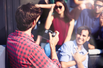 Young man making a photo of his friends