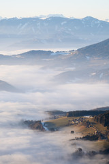 Hill looking through low stratus fog with mountain range Hochschwab - obrazy, fototapety, plakaty