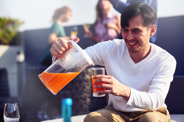Cheerful man pouring juice