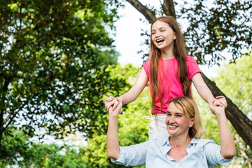 Fototapeta premium Mother and daughter having fun together in a park. Family and lifestyle concept
