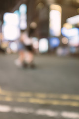 abstract blur and defocused people crossing the street in Hong Kong city at night for background, old film look effect