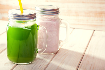 Green healthy smoothie in glass jar on rustik wood