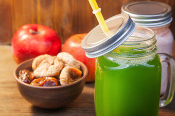 Green healthy smoothie in glass jar on rustik wood
