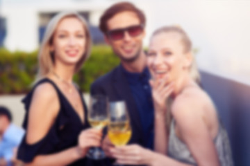 Blurred photo of positive young people at the rooftop party