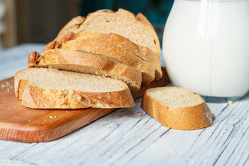 Still life with slices of bread and milk on a wooden background