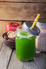 Green healthy smoothie in glass jar on rustik wood