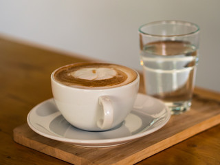 Hot coffee latte art on wooden table.