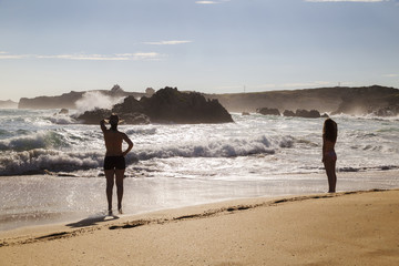 two women walking through the sand of a lonely and beautiful beach
