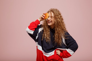 Burger. Beautiful young girl with burger curly hair on pink background. Concept fast food, snack