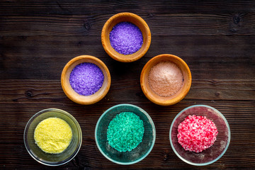Colorful spa salt on dark wooden background top view copy space